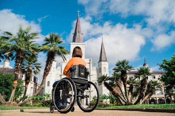 A wheelchair user sitting in front of St. Louis Cathedral